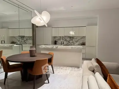 Modern kitchen with marble backsplash and dining area featuring elegant lighting and contemporary furniture.