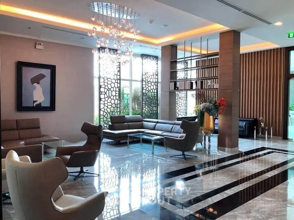 Luxurious modern lobby with elegant seating and stunning chandelier in upscale building.