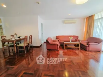 Spacious living room with elegant wooden flooring and cozy seating area.
