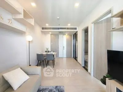 Modern open-plan living room with dining area, stylish decor, and neutral tones.