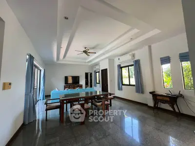 Spacious living room with modern decor and large windows offering natural light