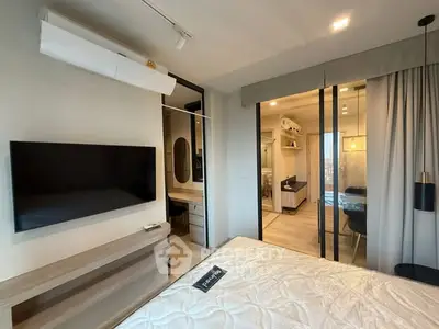 Modern bedroom with sleek design and open view into stylish kitchen area.