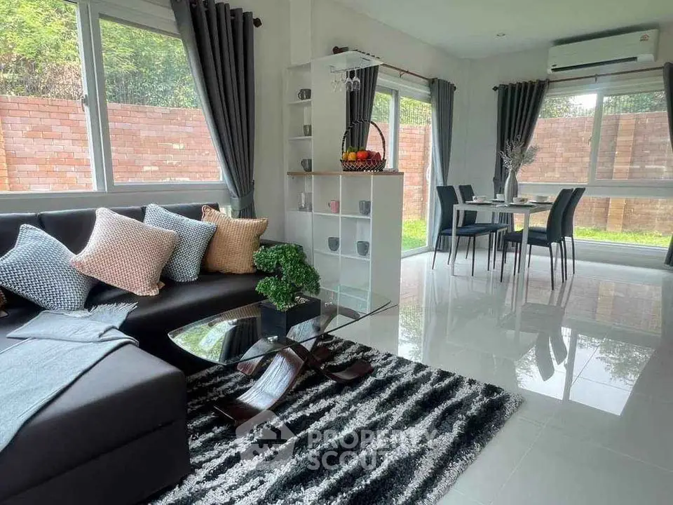 Modern living room with stylish decor and dining area, featuring large windows and garden view.