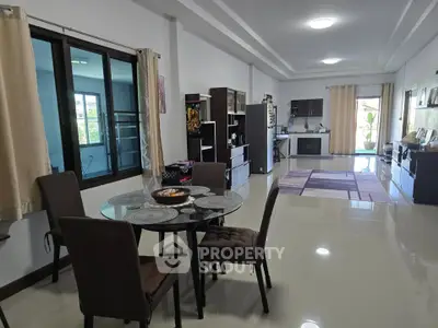 Spacious open-plan living and dining area with modern furnishings and large windows.