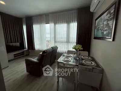 Modern living room with dining area and large windows offering city views.