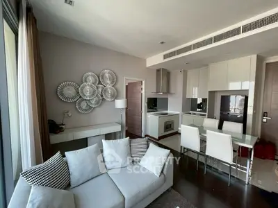 Modern open-plan living room and kitchen with stylish decor and natural light.