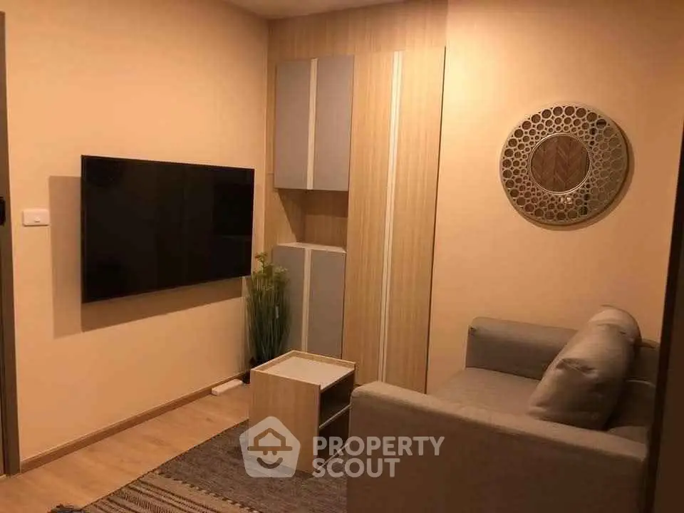 Cozy living room with modern decor and wall-mounted TV in a stylish apartment.