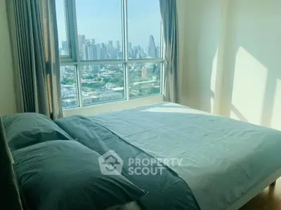 Bright bedroom with large window offering stunning city skyline view