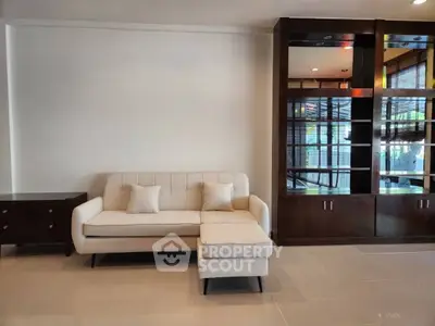 Modern living room with elegant sofa and stylish wooden shelving unit, perfect for contemporary home decor.