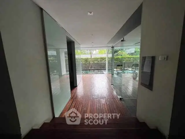 Modern building entrance with glass doors and wooden flooring