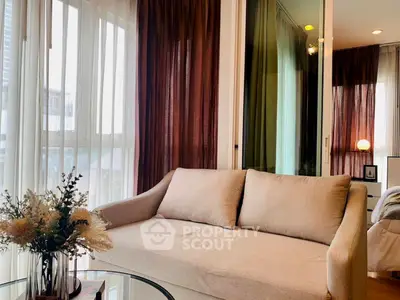 Cozy living room with beige sofa and elegant curtains, perfect for relaxation.