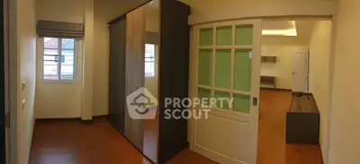 Spacious modern bedroom with sliding doors and wooden flooring