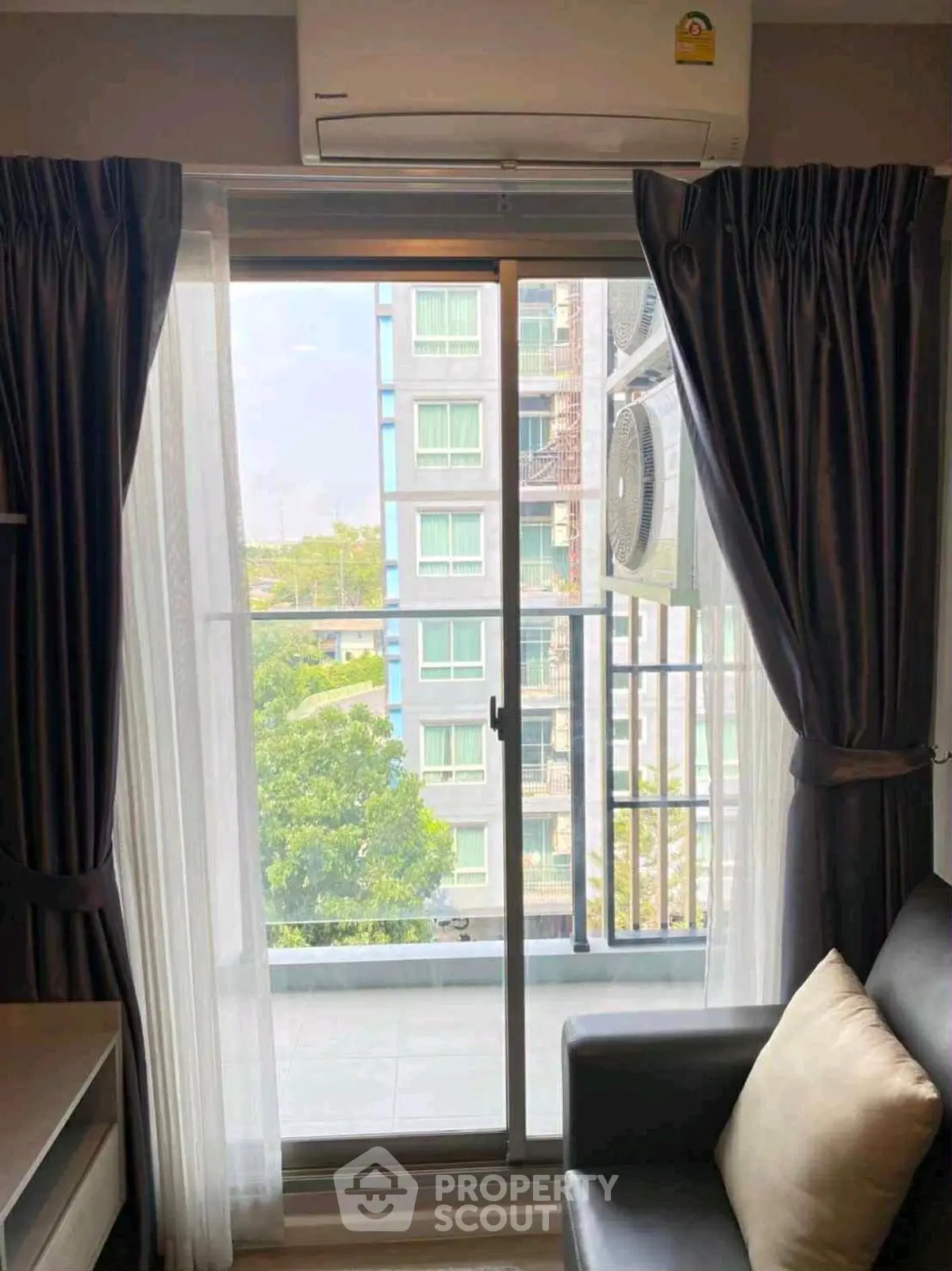 Modern apartment with balcony view and air conditioning, featuring sleek interior design and natural light.