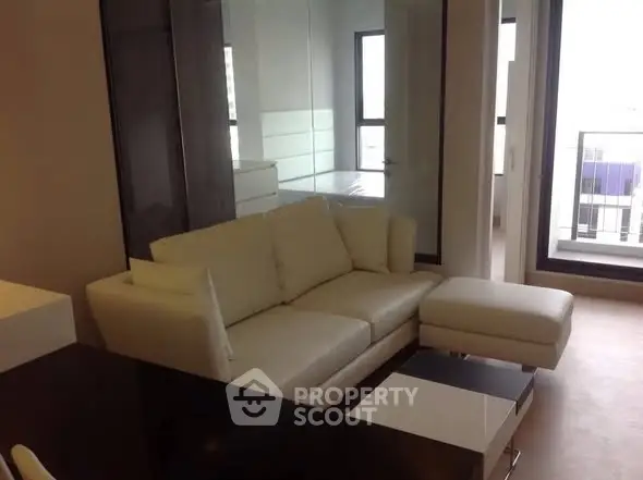 Modern living room with white sofa and glass accents in urban apartment