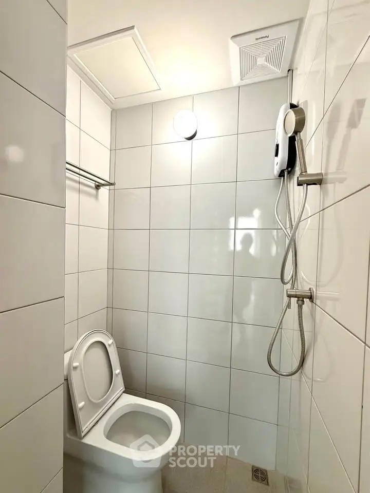 Modern bathroom with sleek white tiles and shower setup
