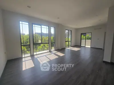 Spacious modern living room with large windows and abundant natural light