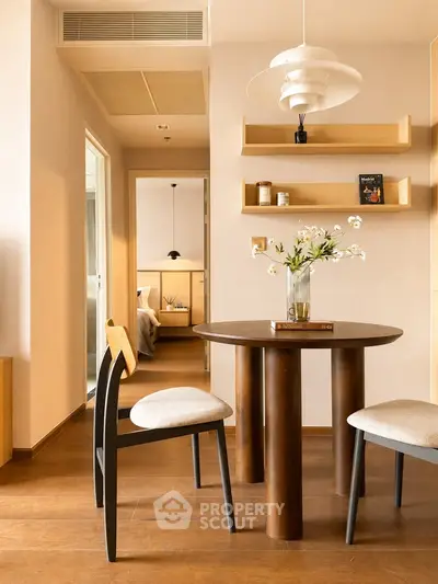 Stylish dining area with modern furniture and open view into cozy bedroom, perfect for urban living.