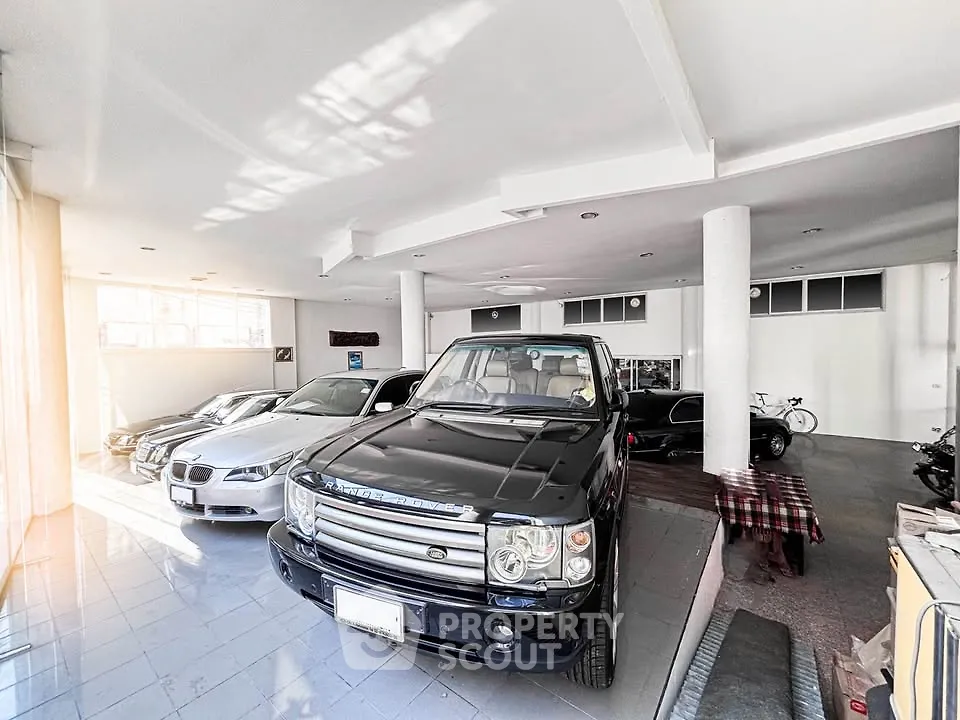 Spacious indoor parking with luxury cars in a modern garage setting.