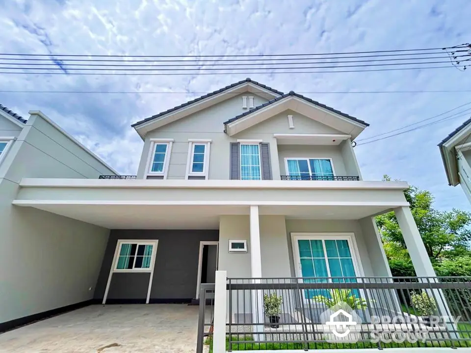 Modern two-story house with spacious driveway and elegant facade under a clear sky.