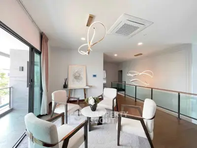 Elegant living room with modern lighting and stylish furniture, featuring a spacious open layout and balcony access.