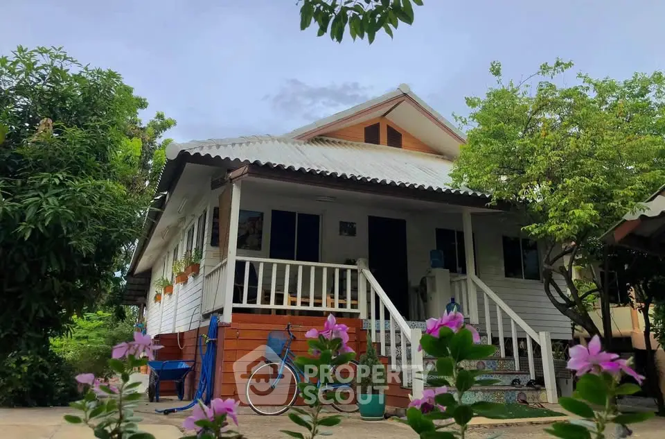 Charming single-story house with lush garden and inviting front porch.