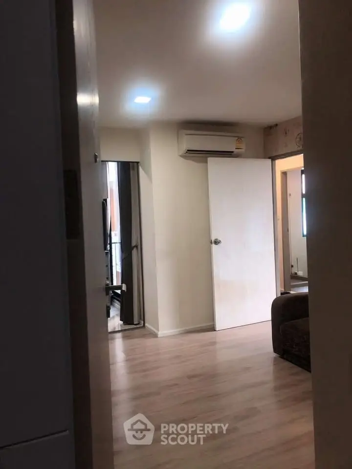 Modern apartment interior with wooden flooring and air conditioning unit.