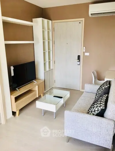 Modern living room with stylish furniture and wall-mounted TV in a cozy apartment.