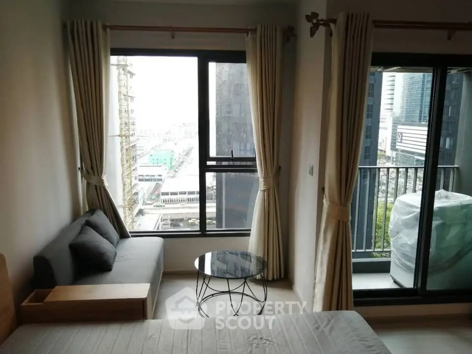 Modern apartment with city view, featuring cozy living area and balcony access.