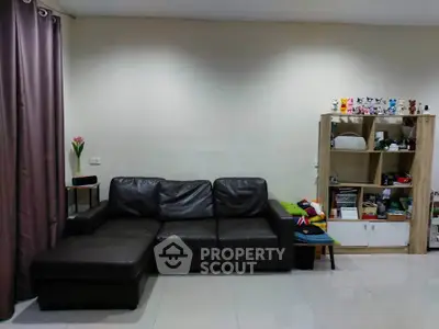 Cozy living room with leather sofa and modern shelving unit, perfect for relaxation and storage.