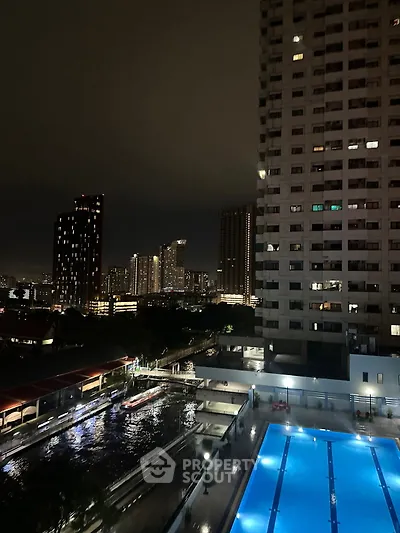 Stunning night view of city skyline with illuminated pool and high-rise buildings.