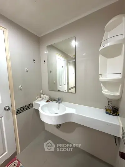 Modern bathroom with sleek sink and wall-mounted mirror in a contemporary home.
