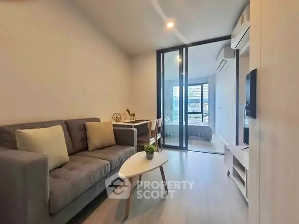 Modern living room with cozy sofa and stylish decor in open layout apartment.