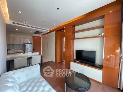 Modern living room with sleek furniture and open kitchen layout in a stylish apartment.