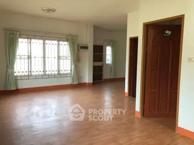 Spacious empty living room with large window and wooden door