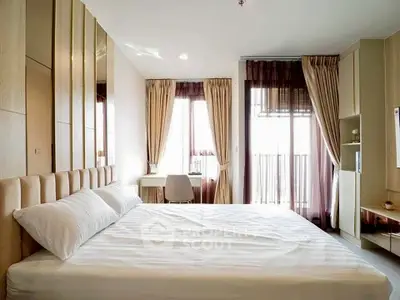 Modern bedroom with large windows and elegant decor, featuring a cozy bed and stylish curtains.