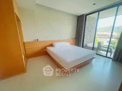 Spacious bedroom with large window and scenic view, featuring modern design and natural light.