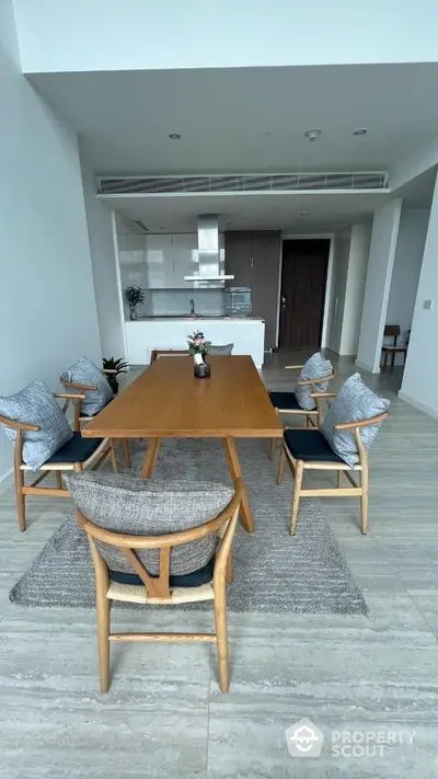 Spacious modern dining area seamlessly integrates with an open-plan kitchen, featuring elegant furniture, sleek finishes, and a welcoming atmosphere perfect for entertaining.