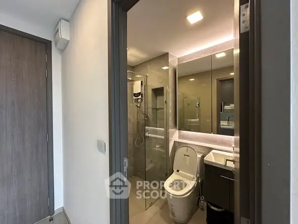 Modern bathroom with glass shower and sleek fixtures in a contemporary apartment.