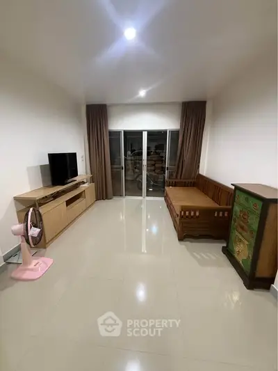 Spacious living room with modern furniture and large sliding glass doors leading to a balcony.