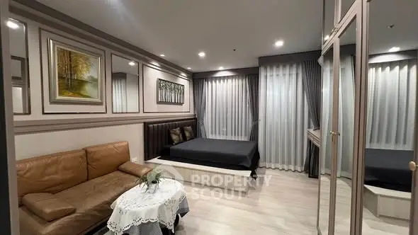 Modern bedroom with elegant decor and cozy seating area in a stylish apartment.