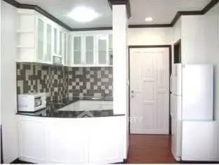 Modern kitchen with sleek cabinetry and stylish backsplash in a compact layout.