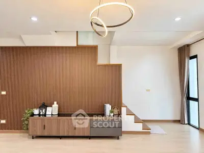Modern living room with stylish wooden paneling and elegant lighting