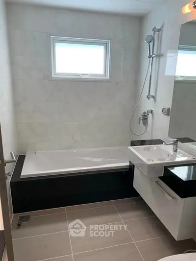 Modern bathroom with sleek design, featuring a bathtub and elegant fixtures.