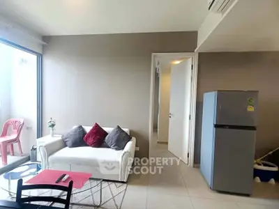 Modern living room with cozy sofa and sleek refrigerator, perfect for urban living.