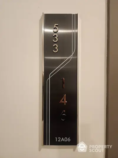 Modern apartment number plaque with sleek design and metallic finish