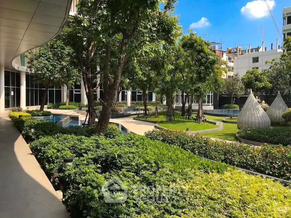 Luxurious garden view of modern residential complex with lush greenery and serene pathways.