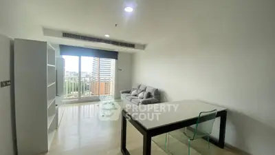 Modern living room with city view, featuring sleek furniture and large windows.