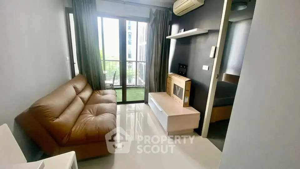 Modern living room with brown leather sofa and balcony view in a stylish apartment.