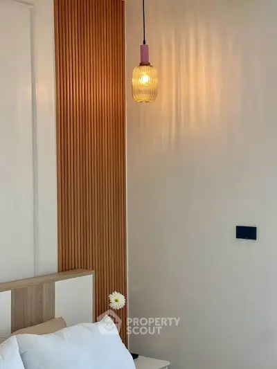 Modern bedroom with stylish lighting and wooden accent wall, creating a cozy and elegant atmosphere.
