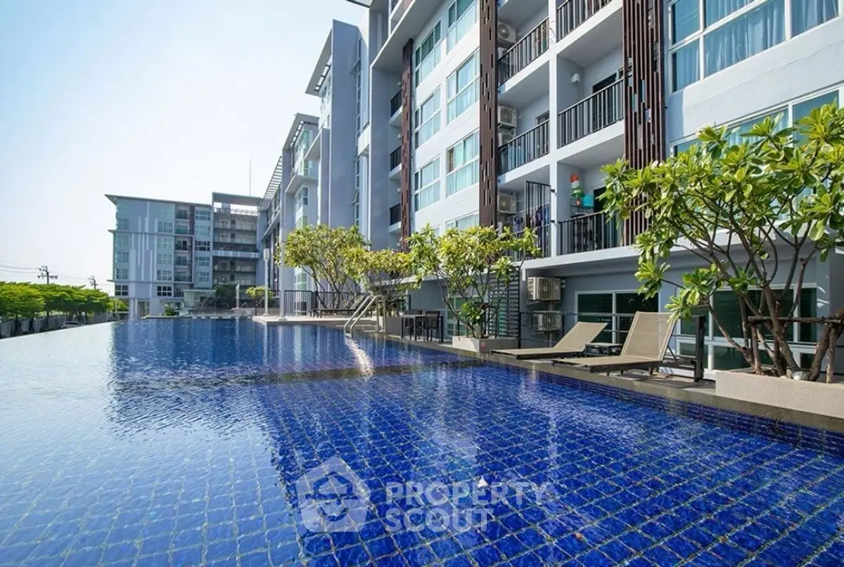 Luxurious modern apartment complex with stunning outdoor pool and lush greenery.